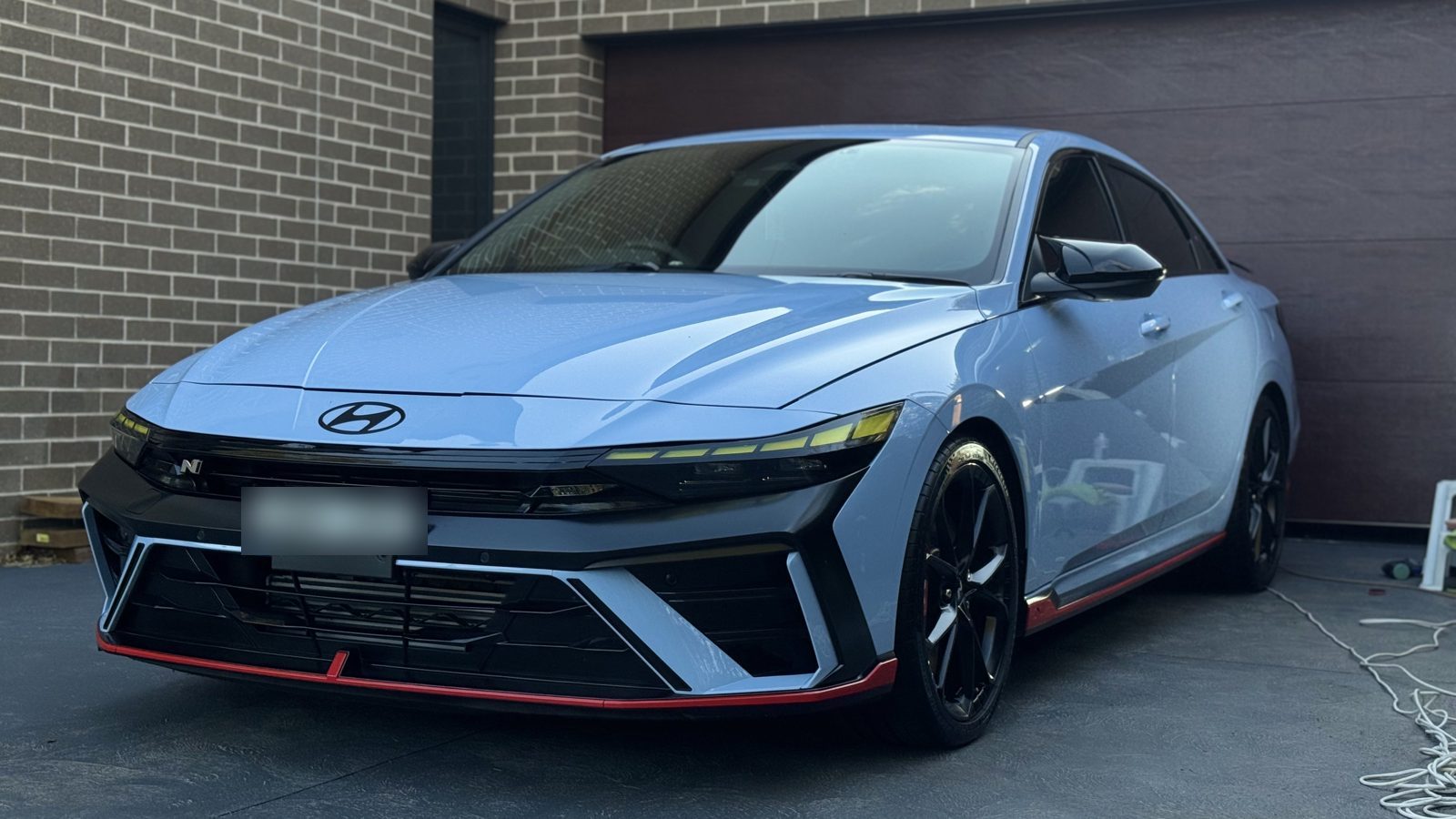 Performance Blue Hyundai i30 Sedan N after ceramic coating, parked in a driveway