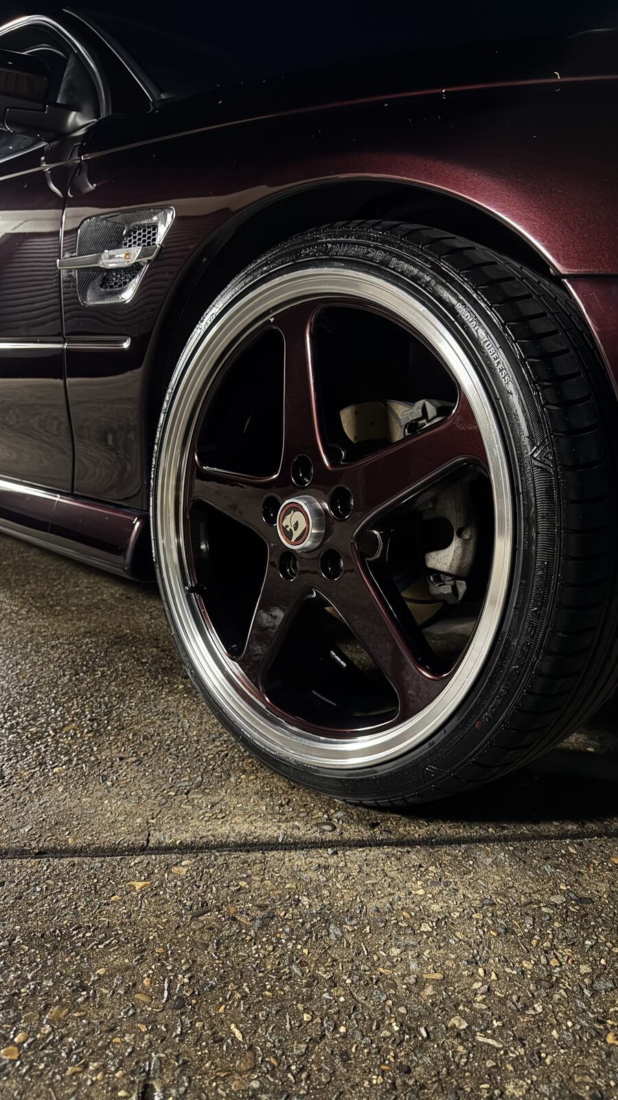 Glossy five-spoke wheel and dressed tyre on a plum HSV Maloo