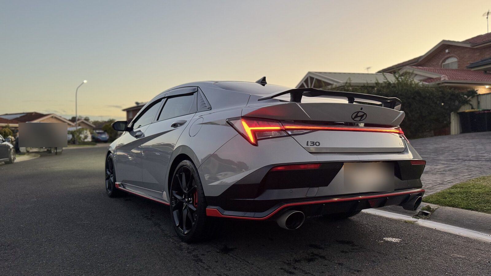Grey Hyundai i30 Sedan N rear three-quarter at sunset after a detail