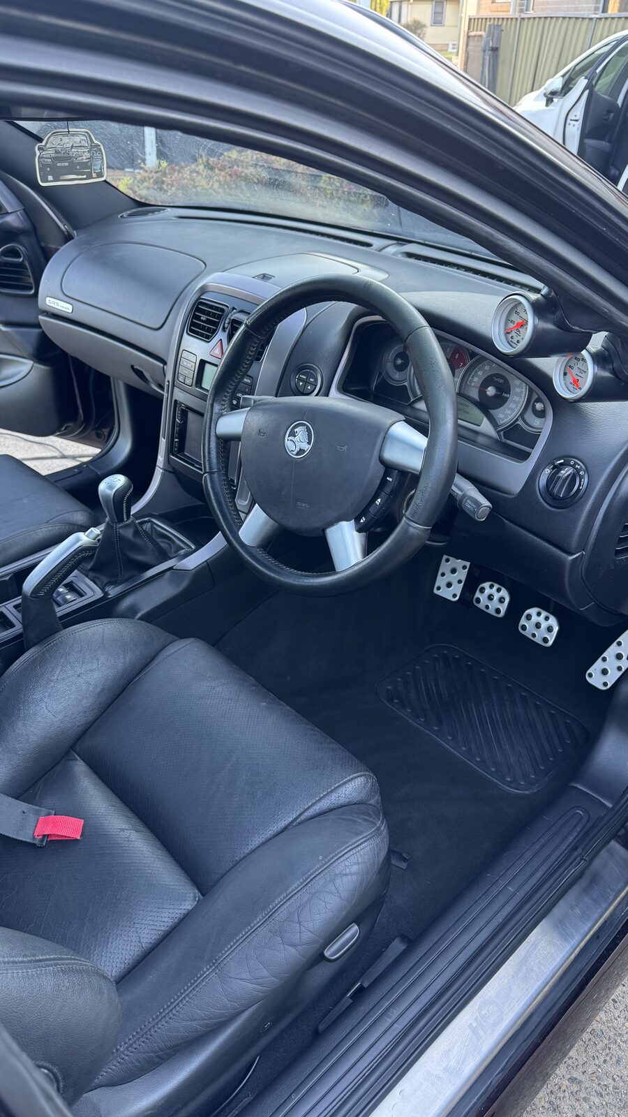 Clean leather seats and dash inside an HSV Maloo seen through the open door