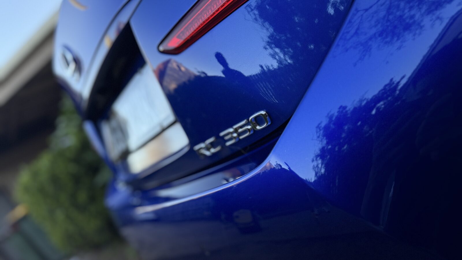 RC 350 badge on glossy blue paint reflecting trees and sky